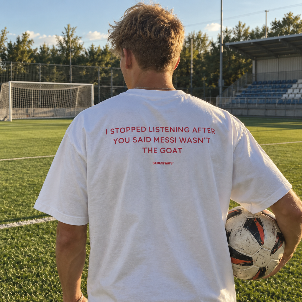 I Stopped Listening After You Said Messi Wasn't The GOAT white tee, worn on a football pitch